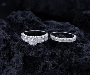 Close-up of S925 sterling silver halo wedding ring set displayed on black volcanic rock