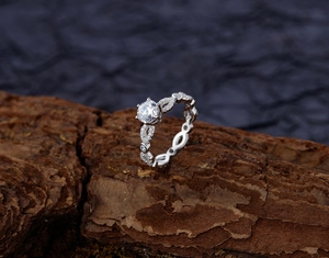 Détail d'une bague en argent S925 avec anneau ajouré et moissanite sur écorce d'arbre