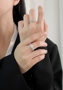 Detail of stacked S925 sterling silver floral rings with sparkling zircon on hand