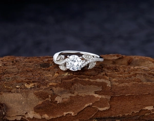 Macro view of leaf design ring featuring a round zircon and micro-paved marquise stones
