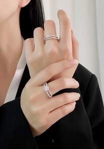 Gros plan de bagues double rangée en argent serties de zircons sur une main de femme
