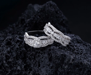 Macro detail of S925 sterling silver wavy rings with micro-pave diamonds on lava rock