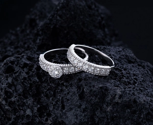 Gros plan de bagues en argent avec pavé de diamants posées sur une pierre volcanique