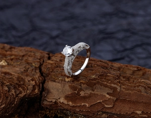 Macro shot of S925 sterling silver ring with rock texture and round zircon on wood
