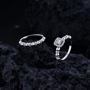Détail de bagues en argent S925 avec diamants sur fond de pierre volcanique noire