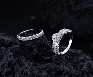 Macro view of a luxury S925 silver engagement ring set with pave diamonds on volcanic rock