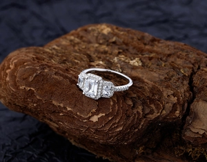 Macro shot of S925 sterling silver ring with emerald cut stones on wooden texture
