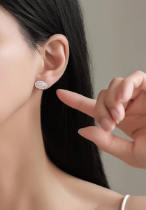 Close-up of S925 sterling silver oval stud earrings with pavé-set shimmering zircon stones