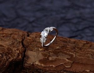 Macro shot of S925 sterling silver leaf ring with round zircon on natural tree bark