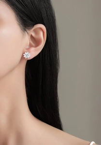 Macro view of crystal daisy stud earring on model showing floral pave setting