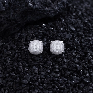 Macro shot of silver cushion-cut stud earrings with micro-pave cubic zirconia on black stone