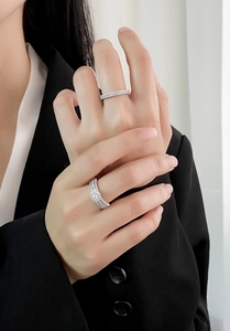 Macro detail of model wearing S925 sterling silver micro-pave diamond rings in layers