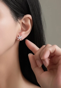 Vue macro de boucles d'oreilles flocon en argent S925 avec zircons cubiques scintillants