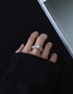 Detailed view of an oval-cut shimmering crystal ring with pavé diamonds on the band