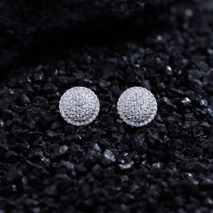Macro shot of micro-paved round stud earrings with sparkling cubic zirconia on black stones