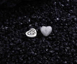 Macro detail of heart stud earrings showing pave-set cubic zirconia and hollow back design