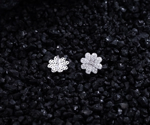 Macro view of S925 silver daisy stud earrings showing zircon micro-pave and pin structure