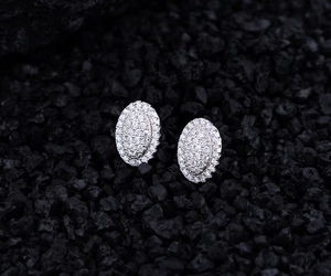 Macro shot of oval S925 silver stud earrings with micro-pave cubic zirconia on volcanic rock