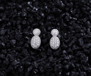 Macro detail of S925 silver oval stud earrings with full pavé zircons and cable borders