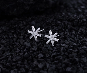 Détail de boucles d'oreilles flocon en argent S925 et zircon sur pierres noires