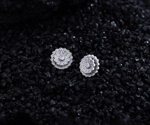 Macro shot of S925 silver double flower stud earrings with pavé zircons on black stone