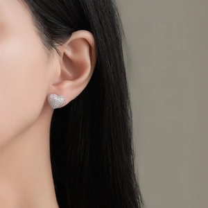 Sparkling double heart stud earrings with cubic zirconia pavé on model's ear