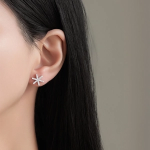 Élégantes boucles d'oreilles flocon de neige en argent S925 et zircone portées par modèle