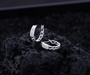 Détail de boucles d'oreilles en argent S925 avec design de chaîne et zircons sertis