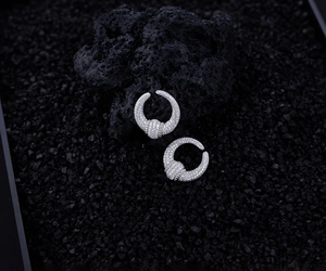 Macro shot of silver S925 U-shape earrings featuring micro-paved sparkling zircon stones