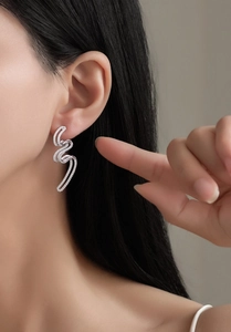 Gros plan de boucles d'oreilles vagues en argent S925 avec zircons sur le mannequin