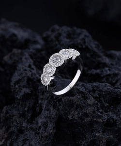 Detailed macro of a S925 sterling silver ring with five halo-set round brilliant zircons