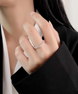 Détail d'une bague éternité en argent S925 avec zircons ronds portés par une femme