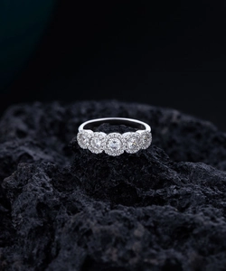 Close-up of five round-cut S925 silver rings with sparkling diamond cluster accents