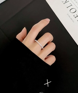 Detail of S925 sterling silver ring with pavé round zircons worn by a model