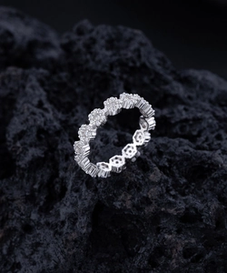Macro shot of silver daisy micro-pave ring with crystals on a dark volcanic rock base