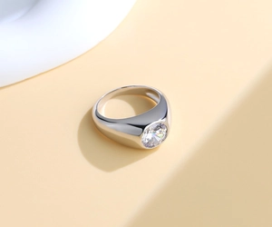 Macro view of wide silver ring with large round solitaire diamond and polished finish