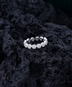 Macro view of S925 sterling silver daisy flower ring with micro-pave diamonds on black rock