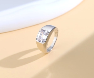 Macro shot of S925 sterling silver stamp and emerald-cut clear stone on a unisex ring