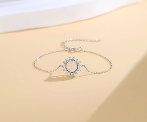 Detail of 925 sterling silver sun-shaped bracelet with opal inlay and zircon accents