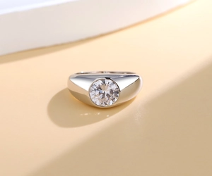 Close-up of a wide silver band ring with a large round-cut sparkling solitaire stone
