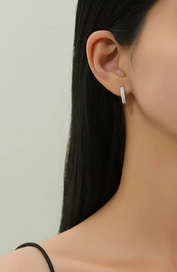 Close-up of S925 silver double-row pave hoop earrings on model with sparkling cubic zirconia
