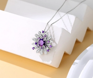 Dettaglio macro del ciondolo margherita in argento S925 con zircone viola e micro-pave