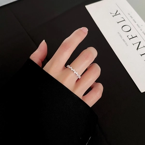 Bague éternité en argent avec micro-pavage et zircones ronds sur le doigt d'une femme