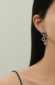 Macro detail of silver layered hoops with pavé crystals on elegant female model