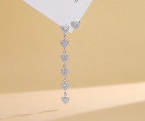 Detail of asymmetric S925 silver heart tassel earrings with sparkling pavé cubic zirconia