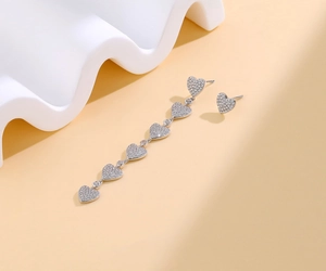 Detailed view of S925 silver asymmetric heart earrings with tassel and pavé zircon stones