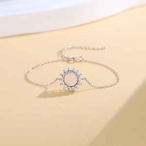 925 silver sunflower opal bracelet with sparkling cubic zirconia on a beige pedestal