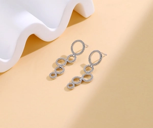 Detail of silver drop earrings with four cascading sparkling rhinestone circles
