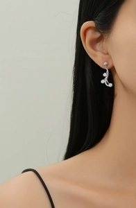 Close-up of S925 sterling silver flower tassel earrings with crystals on earlobe