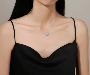 Close-up of a sparkling 925 sterling silver heart necklace worn by a female model